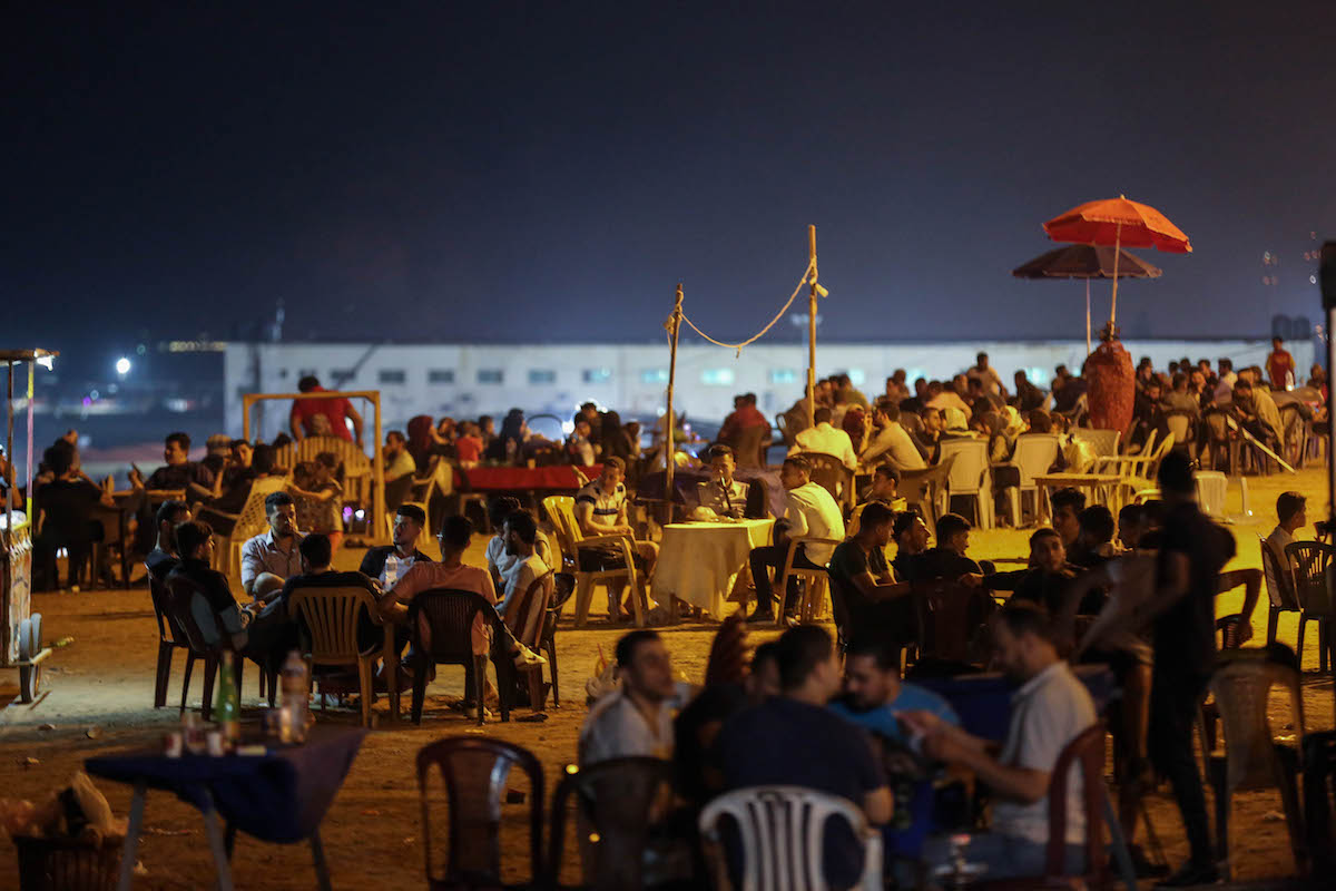 Gazan families sit along the beach in Gaza City. For many, the sea is a momentary escape from their dire economic condition (Mohamed Al Hajjar)
