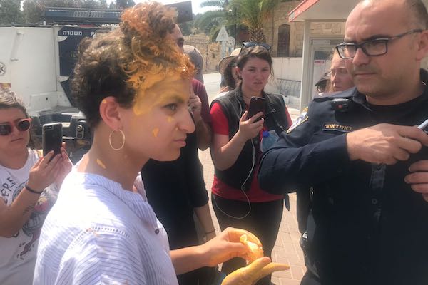 Breaking the Silence staffer Frima (Murphie) Bubis is seen speaking with Israeli police after a settler child threw paint on her head during a tour in Hebron, July 16, 2018. (Mairav Zonszein)