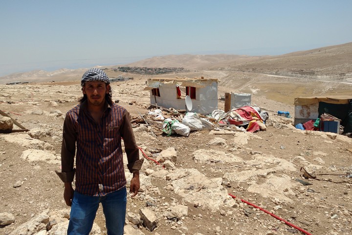 Harba Hamadin, a resident of the Bedouin community Abu Nawar, stands in front of the buildings demolished by Israeli authorities in his village, July 10, 2018. (Orly Noy)