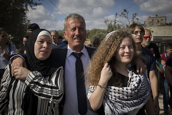 Nariman Tamimi (left), Bassem Tamimi (center), and Ahed Tamimi (right) walk into Nabi Saleh after Nariman and Ahed are released from Israeli prison, July 29, 2018. (Oren Ziv)