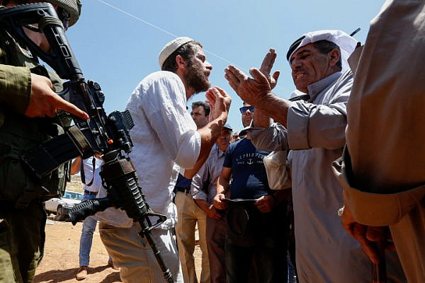 An Israeli settler argues with Palestinians during a protest against a new tent placed by Jewish settlers near the West bank village of Bani Naem on June 23, 2018 (Wisam Hashlamoun/Flash90).