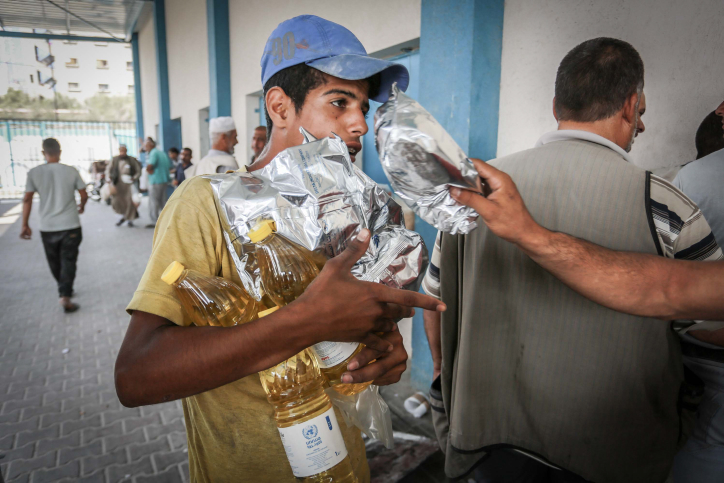 Palestinians receive aid packs from the United Nations Relief and Works Agency for Palestine Refugees (UNWRA) in Rafah, southern Gaza Strip, on September 27, 2018. (Abed Rahim Khatib/Flash90)