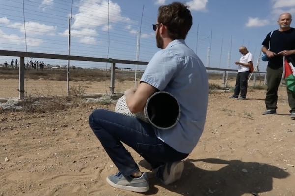 An Israeli activist plays the darbuka for Palestinian protesters on the other side of the Gaza-Israel fence. (Screenshot by Haim Schwarczenberg)