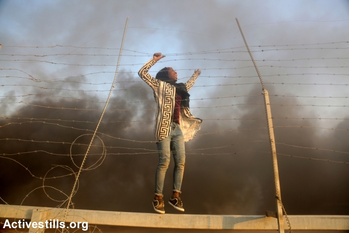 A Palestinian woman seen after after crossing the a fence that had been damaged by demonstrators during the protest near the Gaza-Israel border fence, Gaza Strip, September 28, 2018. (Mohammed Zaanoun/Activestills.org)