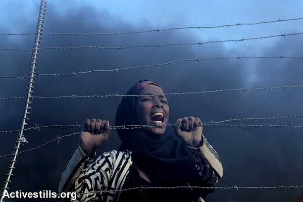 A Palestinian woman seen after after crossing the a fence that had been damaged by demonstrators during the protest near the Gaza-Israel border fence, Gaza Strip, September 28, 2018. (Mohammed Zaanoun/Activestills.org)