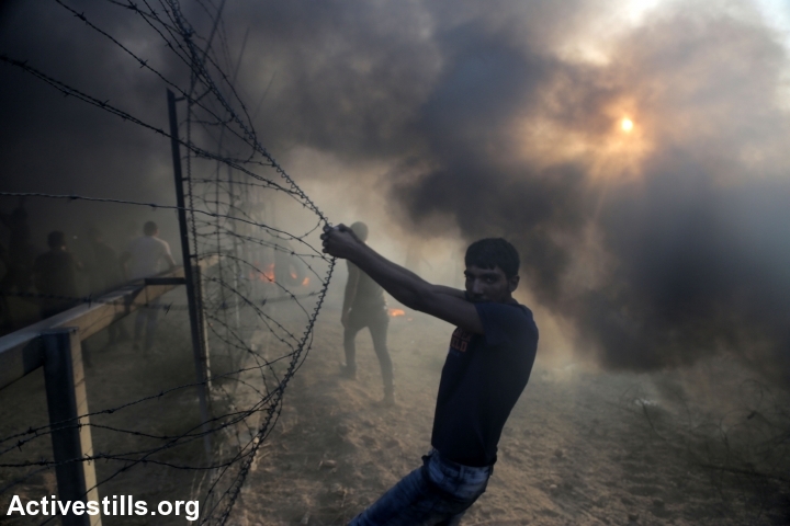 Palestinian protesters seen at the Gaza border fence, during a 'Great Return March' protest, Gaza Strip, September 28, 2018. (Mohammed Zaanoun/Activestills.org)