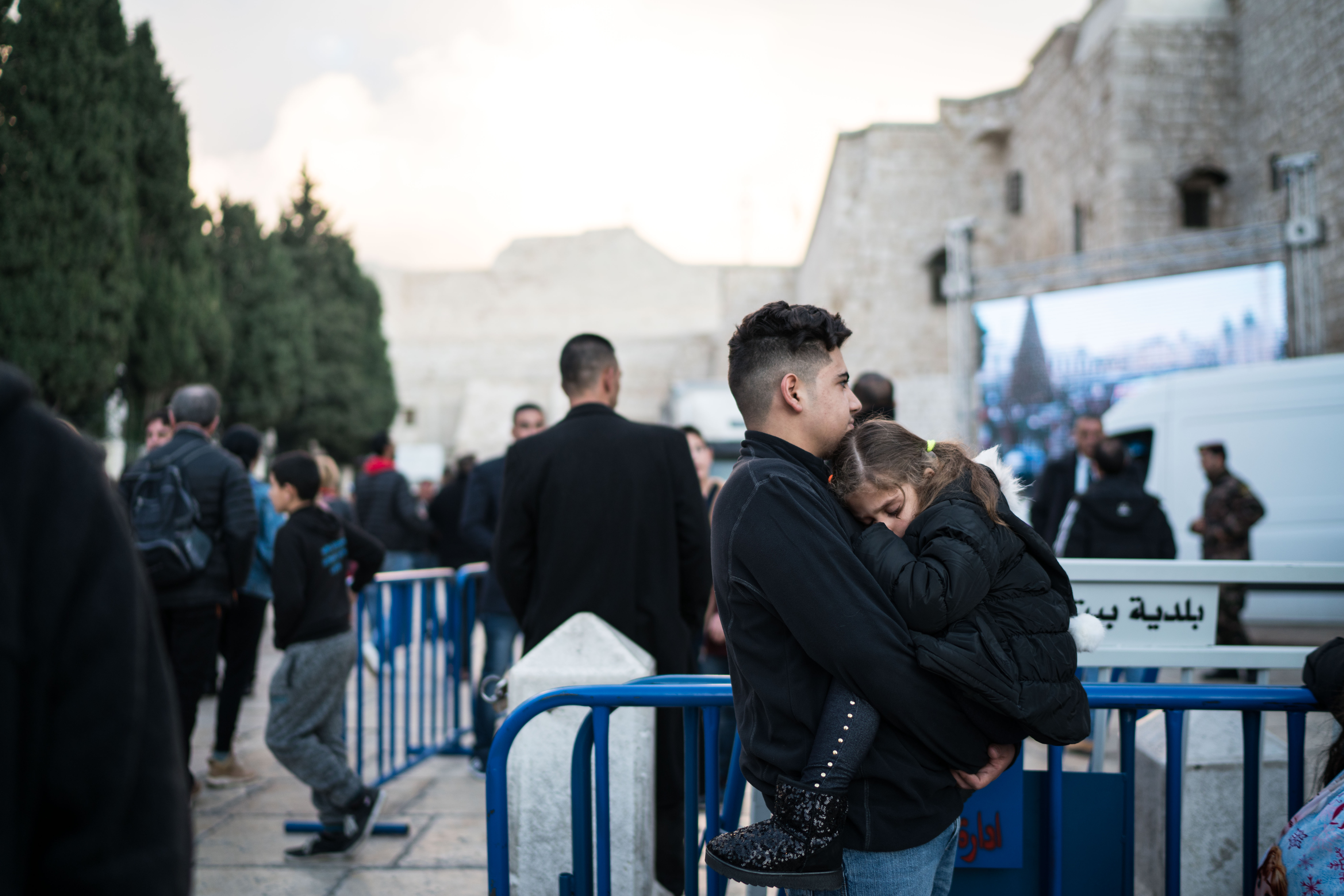 Salim carries his cousin, whom he hasn't seen for three years, outside the Church of the Nativity in Bethlehem on December 24, 2018.