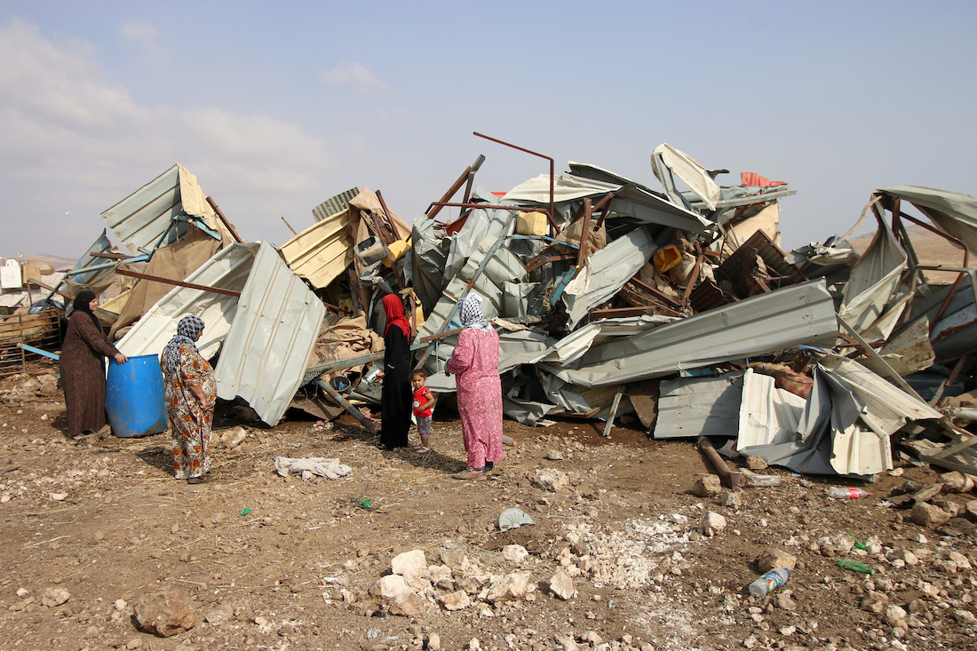 Palestinian women examine the damage caused to their home after an Israeli army demolition in the Jordan Valley village of Al-Hadidya, October 11, 2018. (Ahmad al-Bazz/Activestills.org)