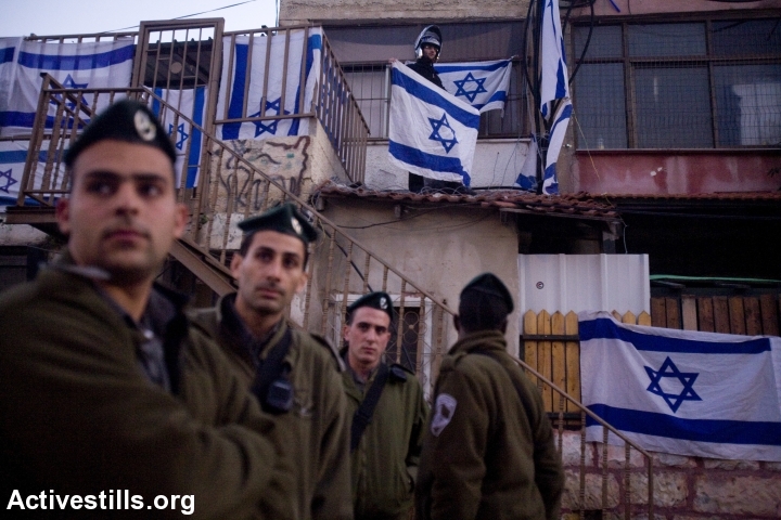 Israeli Border Police officers look on during a protest against the eviction of Palestinians from their homes by Israeli settlers in the East Jerusalem neighborhood of Sheikh Jarrah, December 25, 2009. (Oren Ziv/Activestills.org)