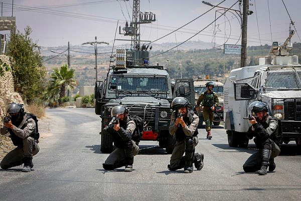 Israeli Border Police officers take positions during clashes with Palestinian protesters in the West Bank city of Hebron, July 14, 2018. (Wisam Hashlamoun/Flash90)