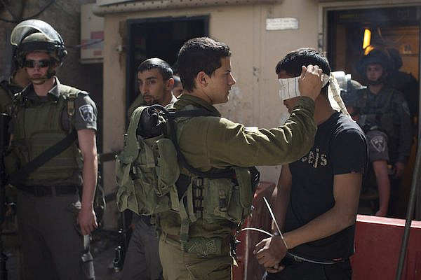 Israeli soldiers arrest a Palestinian in Hebron. File photo by Activestills.org