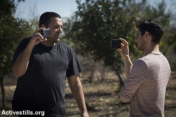 An Israeli settler (left) films a member of Breaking the Silence group during a tour in Hebron, West Bank, February 24, 2016. (Oren Ziv/Activestills.org)
