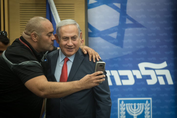 Prime Minister Benjamin Netanyahu poses for a selfie with a Likud activist during a party faction meeting in the Knesset, July 9, 2018. (Hadas Parush/Flash90)