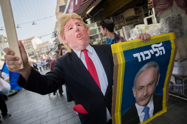 A Likud party supporter wears a Donald Trump mask during a Likud election campaign event at Mahane Yehuda market in Jerusalem, April 7, 2019. (Yonatan Sindel/Flash90)