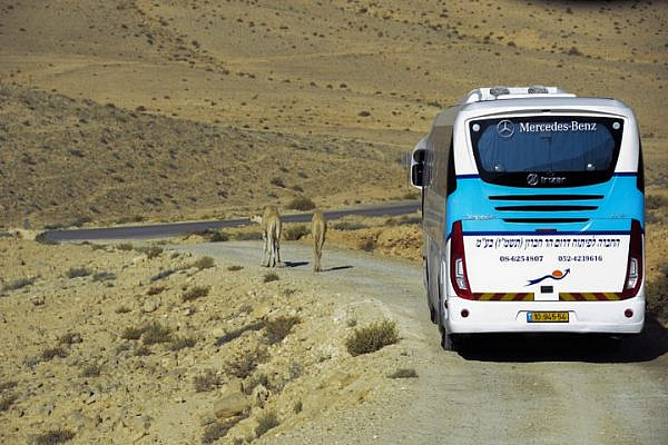 Illustrative photo of an Israeli bus driving along an unpaved road in the Negev/Naqab desert. (Zoe Vayer/Flash90)