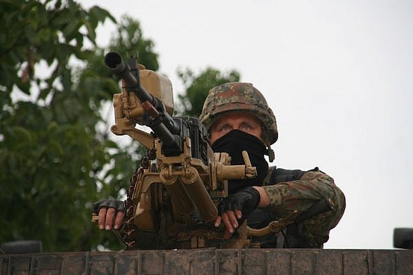 A soldier of the Azov Battalion mans a heavy machine gun on a patrol near Mariupol, Ukraine. (Carl Ridderstråle/CC BY-SA 4.0)