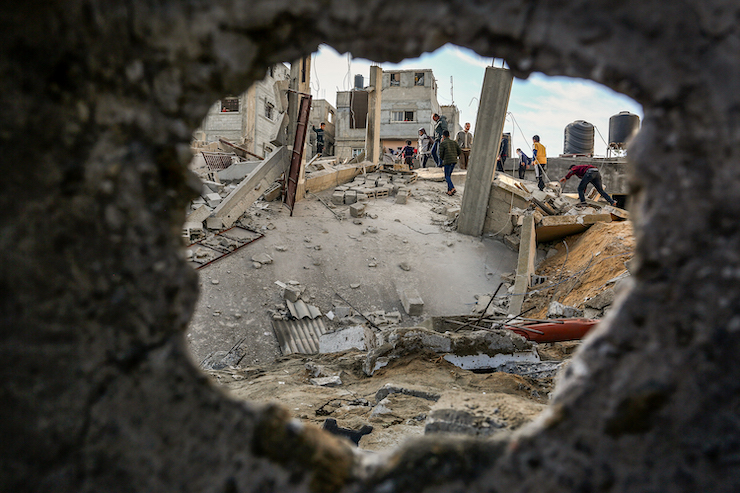 Palestinians walk through the wreckage of a building that was damaged by Israeli air strikes in Rafah in the southern Gaza Strip, on May 5, 2019. (Abed Rahim Khatib/Flash90)