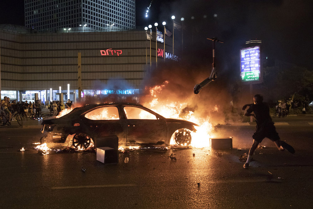 Protesters set fire to a vehicle in central Tel Aviv during a demonstration by Ethiopian Israelis against police killings, July 3, 2019. (Oren Ziv/Activestills.org)