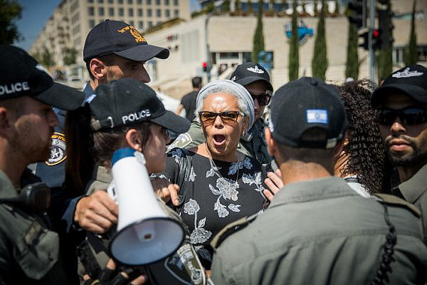 Israeli police surround an Ethiopian Israeli woman at a protest following the police killing of a young black man a few days earlier, Jerusalem, July 15, 2019. (Yonatan Sindel/Flash90)