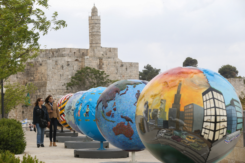 Visitors walk by an art installation at the Alrove-Mamilla Esplanade near Jerusalem's Old City. Each globe symbolizes a proposed solution to climate change, April 17 2013. (Nati Shohat/Flash90)