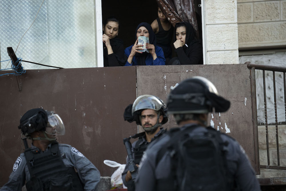 Palestinian women look on during a raid by Israeli police in the East Jerusalem neighborhood of Issawiya, July 1, 2019. (Oren Ziv/Activestills.org)