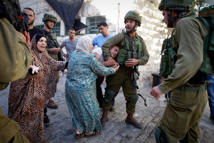 Israeli soldiers detain a Palestinian man following a house raid in the West Bank city of Hebron September 20, 2016. (Wisam Hashlamoun/Flash90)