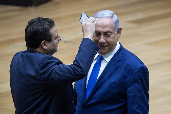 Joint List party leader Ayman Odeh films Israeli Prime Minister Benjamin Netanyahu during a discussion on the "camera law" at the Knesset in Jerusalem on September 11, 2019. (Yonatan Sindel/Flash90)