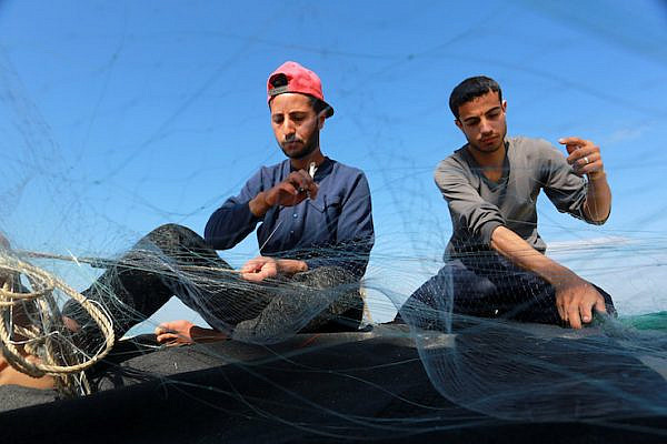 Palestinian fishermen prepare their nets near the sea in Khan Younis in the southern Gaza Strip on March 10, 2019. (Abed Rahim Khatib/ Flash90)