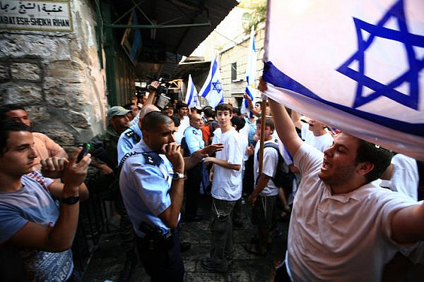 A Jewish Israeli man shouts at Palestinians while waving the Israeli flag in the Muslim Quarter of the Old City of Jerusalem on Jerusalem Day, June 2, 2008. (Nati Shohat/Flash90)