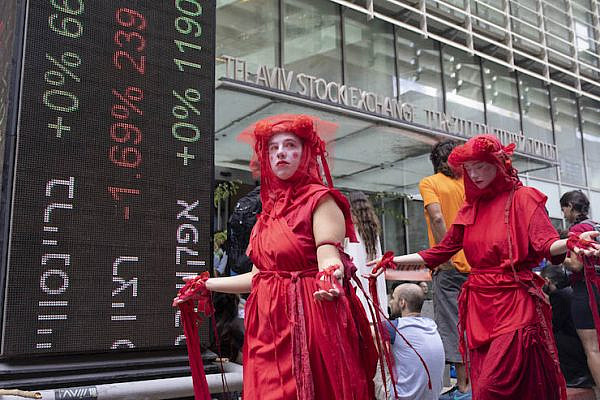 Members of the 'Red Brigade' demonstrate outside the Tel Aviv Stock Exchange, demanding Israeli corporations cease profiting off of the climate crisis, October 7, 2019. (Oren Ziv/Activestills.org)