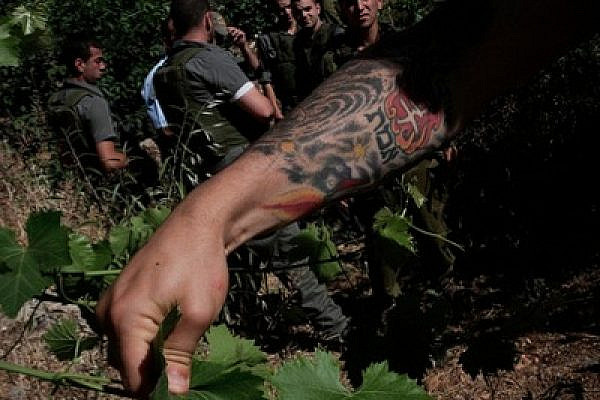 IDF prevents Saffa villagers from harvesting their grapes in 2009. The Hebrew tattoo says "truth." (photo: Anne Paq/Activestills.org)