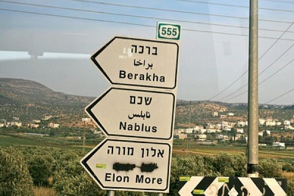 West Bank highway signs, with the Arabic defaced at bottom (photo: Lisa Goldman)