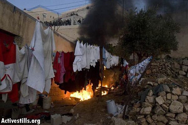 A Palestinian house burning; the fire was lit by settlers (Illustrative photo: flickr/Activestills)