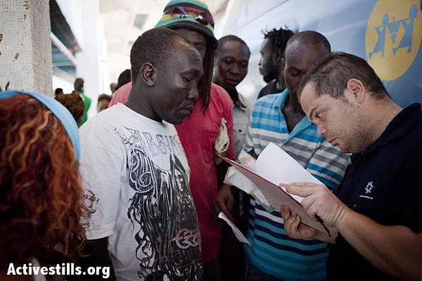 A representative of the Authority of Population and Immigration checks the names of South Sudanese people that are being deported. Tel-Aviv, Israel, August 8, 2012. (Photo: Shiraz Grinbaum/Activestills.org)