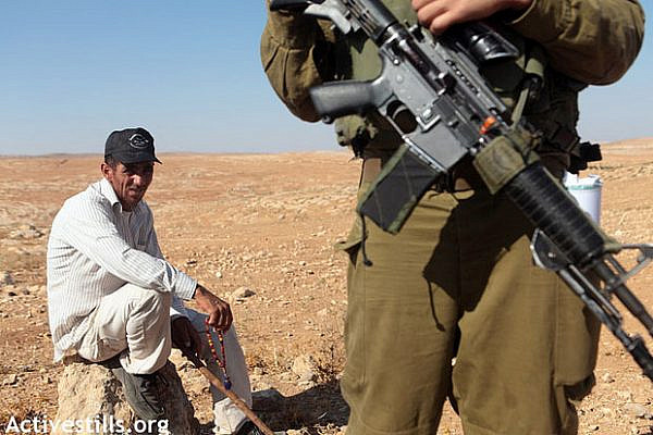 Palestinian shepherd in Um Faqara prevented from reaching his land by IDF soldiers August 2012 (Activestills)