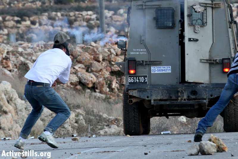 Mustafa Tamimi, a 28 year-old Palestinian from Nabi Saleh, seconds before an Israeli soldier shoots him in the face with a tear gas canister from a short distance, Nabi Saleh, December 12, 2011. (Haim Scwarczenberg)