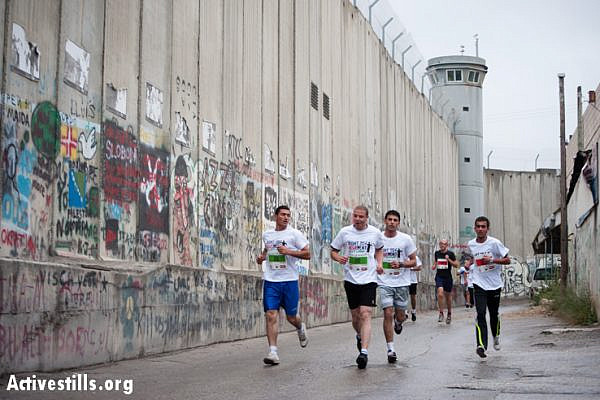 Runners race along the Israeli separation wall as hundreds of Palestinian and international athletes took part in the the inaugural Palestine Marathon which took place in Bethlehem, West Bank, April 21, 2013. Under the title "Right to Movement", runners had to complete two laps of the same route, as organizers were unable to find a single course of 42 uninterrupted kilometers under Palestinian Authority control.