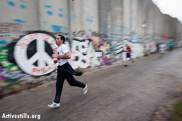 Runners race along the Israeli separation wall as hundreds of Palestinian and international athletes took part in the the inaugural Palestine Marathon which took place in Bethlehem, West Bank, April 21, 2013. Under the title "Right to Movement", runners had to complete two laps of the same route, as organizers were unable to find a single course of 42 uninterrupted kilometers under Palestinian Authority control.