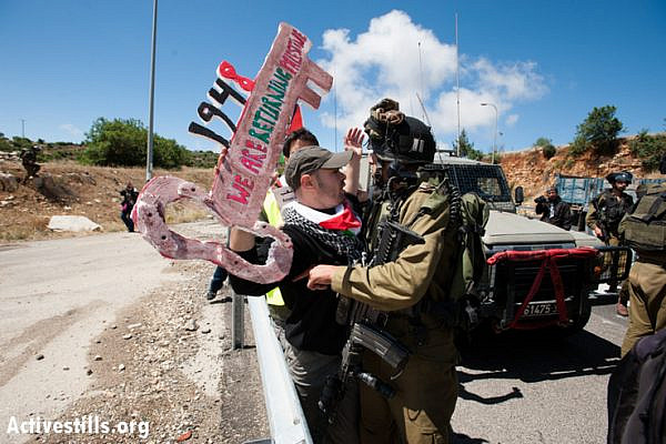 Palestinian activists confront Israeli soldiers during a march on Road 60, the main North-South route through the West Bank, in a Nakba Day protest, May 15, 2013.  The Nakba, literally, the "catastrophe", names the massive deportation of more then 700,000 Palestinian, made refugees and driven out of what became the State of Israel in 1948. (Photo by: Ryan Rodrick Beiler/Activestills.org)