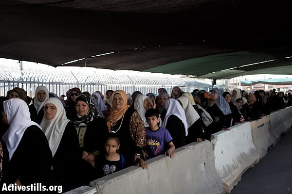 Palestinian women wait to cross from Qalandiya checkpoint outside Ramallah, West Bank, into Jerusalem to attend the Ramadan Friday Prayers in the Al-Aqsa Mosque, July 19, 2013. (Photo by: Oren Ziv/ Activestills.org)