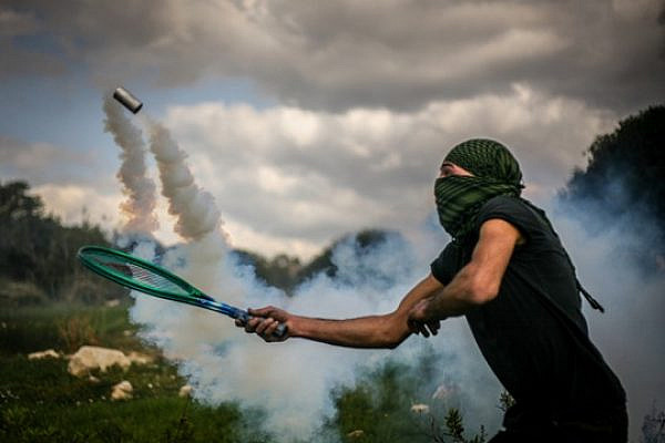 "Return Serve", a Bil'in demonstrator sending tear gas back to the army (Photo: Hamde Abu Rahma)