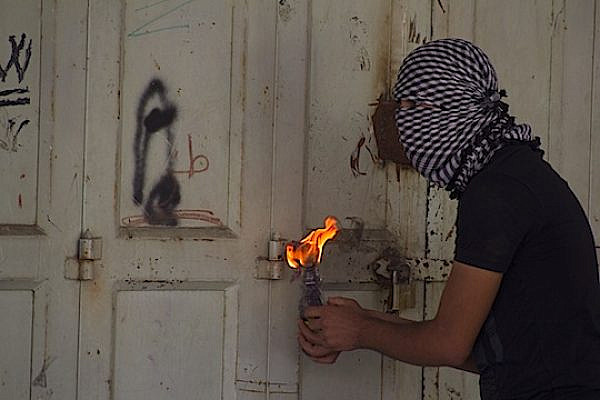 A Palestinian protester prepares a molotov cocktail during clashes with IDF soldiers in Hebron. (photo: Elias Nawawieh)