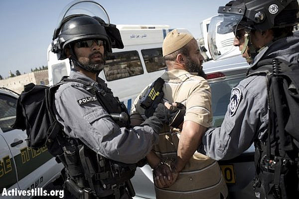 Israeli policemen arrest a Palestinian man after tasing him in the East Jerusalem neighborhood of Ras al Amud, September 27, 2013. Israeli police closed off prayer to Palestinian worshipers under the age if 50 in the Al-Aqsa Mosque, forcing Palestinians to pray in different locations outside of checkpoints. (Activestills)