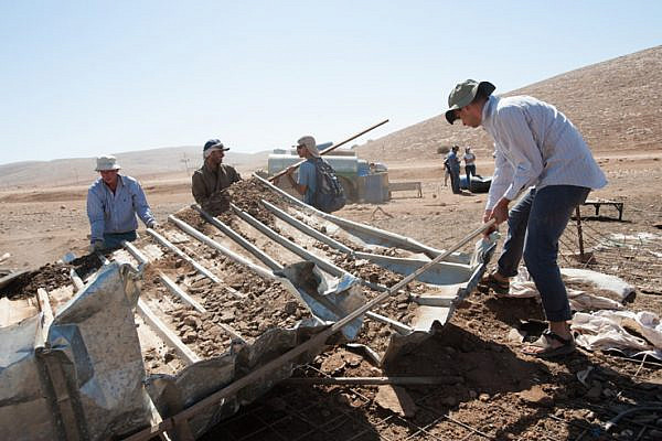 Palestinians, aided by Israeli solidarity activists, clear the remains of demolished shelters in the destroyed West Bank village of Khirbet al-Makhoul, Jordan Valley, October 11, 2013.