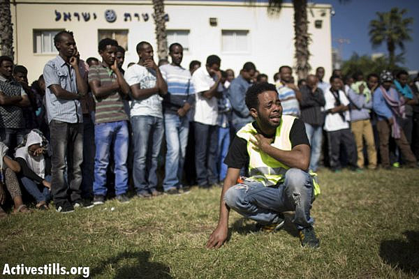 Eritrean refugees grieve as they attend a memorial service held in Levinsky Park in South Tel Aviv, on October 12, 2013, to honor the victims of the Lampedusa Shipwreck.