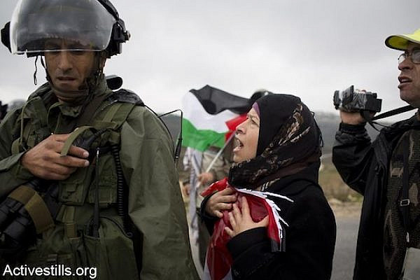 Nariman Tamimi, wife of Bassem Tamimi and sister of Rushdi Tamimi, who was killed by the Israeli army a week before this picture was taken, shouts at a border policeman during the weekly protest against the occupation in the West Bank village of Nabi Saleh, November 23, 2012. (Photo: Oren Ziv/Activestills.org)