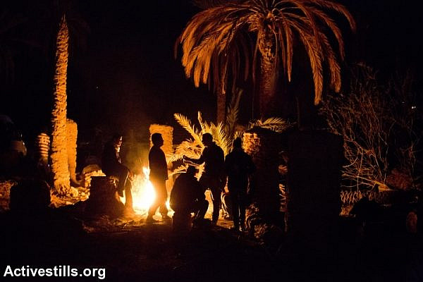 Palestinian activists around a bonfire in Ein Hijleh protest village, in the Jordan Valley, West Bank January 31, 2014.