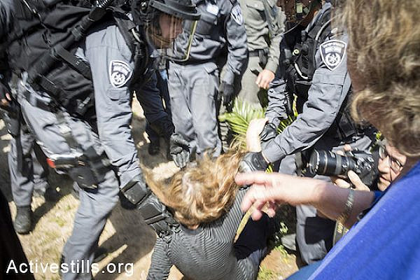 Policemen hold down a protester during the evacuation of the Givat Amal neighborhood. Protesters chanted slogans and burned tires. (photo: Shiraz Grinbaum/Activestills.org)