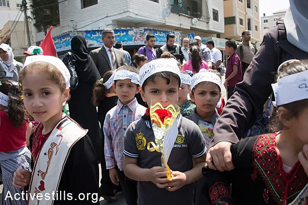 Palestinian children hand out flowers to passers-by on the streets of Gaza City with the names of prisoners in Israeli detention, May 11, 2014. More than 100 Palestinian administrative detainees in Israeli prisons launched a mass, open-ended hunger strike on Thursday, April 24, 2014. The hunger strike comes after Israeli authorities reneged on an agreement after a previous hunger strike to limit the use of administrative detention to exceptional cases.