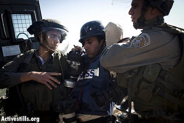 Israeli soldiers arrest a Palestinian journalist (photo: Activestills.org)